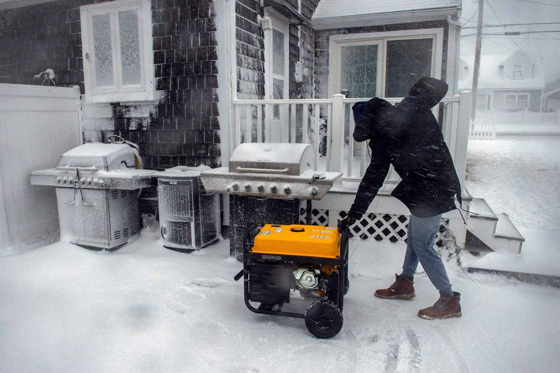 A man starts a generator at his home after losing power during a snow storm in Marshfield, Massachusetts, on January 29, 2022.