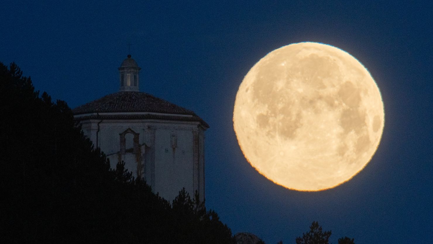 Nicknamed the snow moon, the golden orb will appear almost like any ordinary full moon. Here, the snow moon looms in the sky over Abruzzo, Italy, in February 2022.