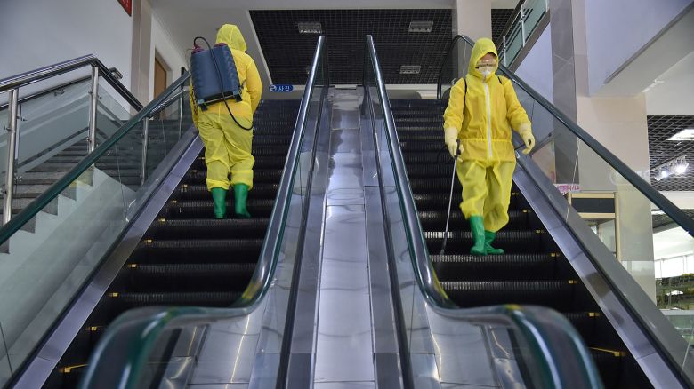Employees spray disinfectant as part of preventative measures against the Covid-19 coronavirus at the Pyongyang Children's Department Store in Pyongyang on March 18, 2022.