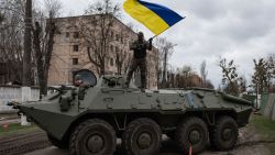 HOSTOMEL, UKRAINE - APRIL 08: Ukrainian soldier waves Ukrainian national flag while standing on top of an armoured personnel carrier (APC) on April 8, 2022 in Hostomel, Ukraine. After more than five weeks of war, Russia appears to have abandoned its goal of encircling the Ukrainian capital. However, Ukraine expects a renewed fight in the east and south. (Photo by Alexey Furman/Getty Images)