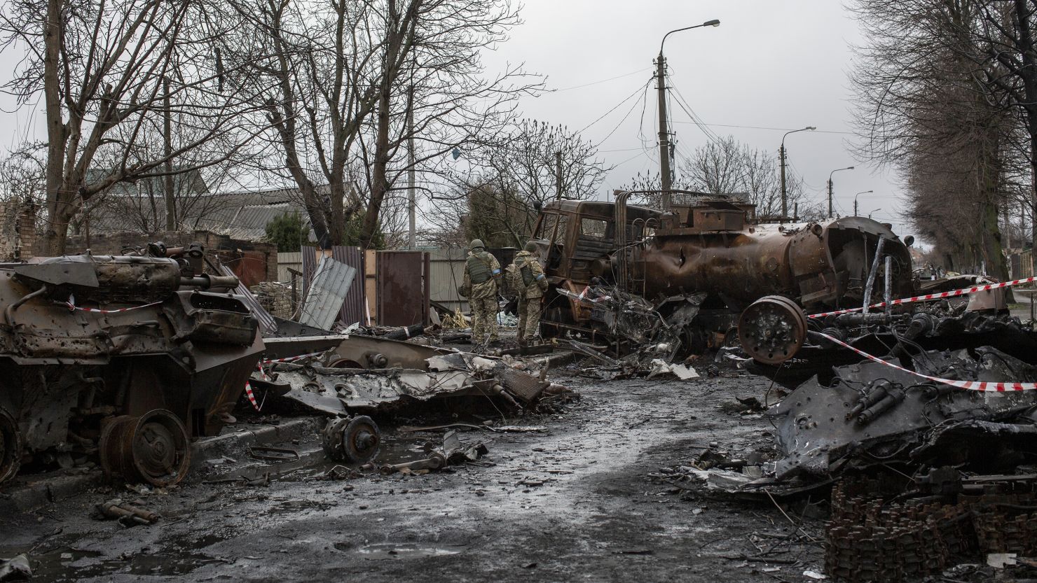 Ukrainian servicemen inspect the wreckage of Russian military vehicles in the town of Bucha, on the outskirts of Kyiv, on April 8, 2022 following the Russian forces' withdrawal.