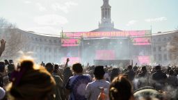 A cloud of smoke rises over people smoking as a clock hits 4:20pm while musician Lil Jon performs during the Mile High 420 Festival in Denver, Colorado, on April 20, 2022, known by some as 'Weed Day'. Tens of thousands of cannabis enthusiasts gathered in Denver on April 20 to celebrate the ever-widening US legalization of recreational weed with plumes of pungent smoke, music... and a few grumblings about commercialization. April 20 has become the national holiday for the herb in the United States, as the date corresponds with the "420" slang name for marijuana. (Photo by Patrick T. FALLON / AFP) (Photo by PATRICK T. FALLON/AFP via Getty Images)