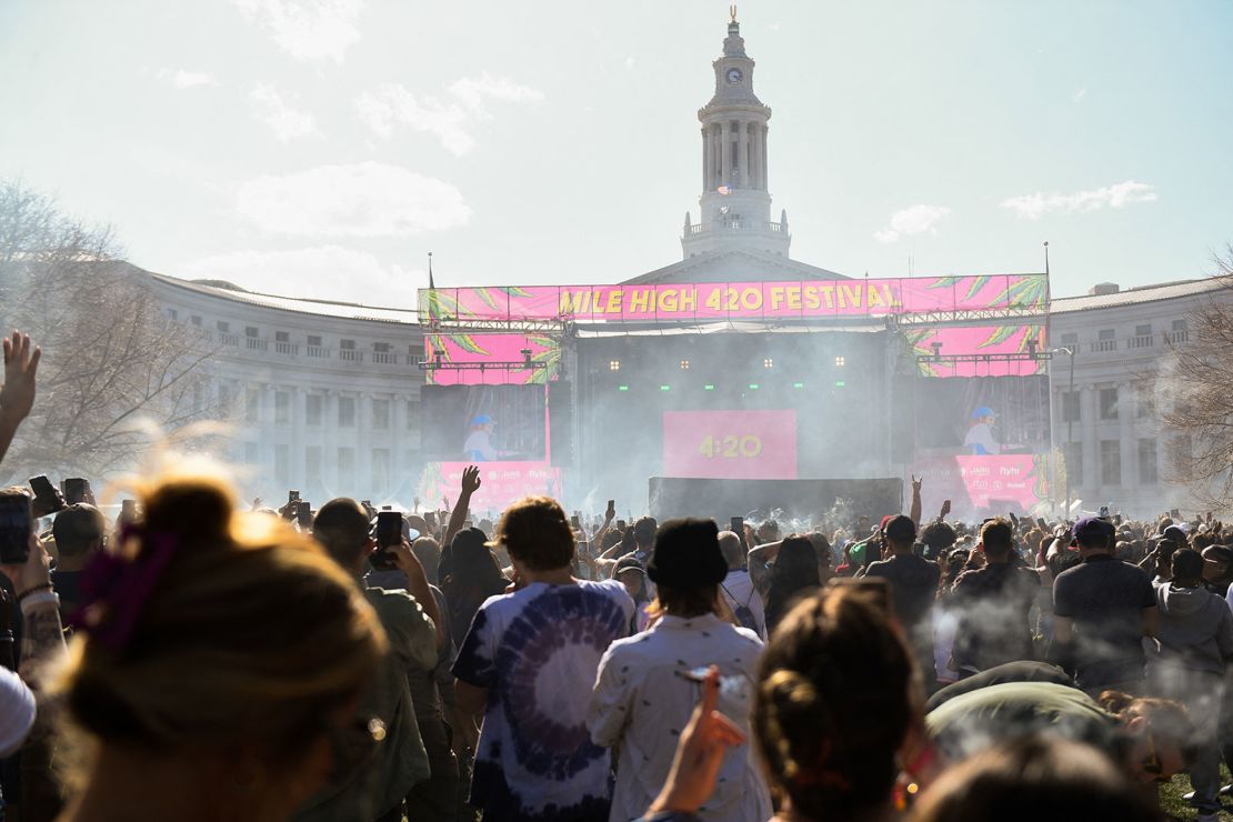 A cloud of marijuana smoke rises as a clock hits 4:20 p.m. during the Mile High 420 Festival in Denver on "weed day" in 2022.