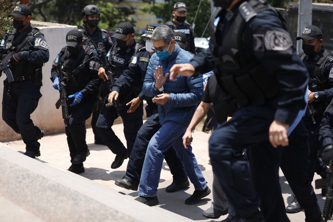 Honduran police officers escort Juan Orlando Hernández, Honduras' former president, to the airport in Tegucigalpa on April 21, 2022.