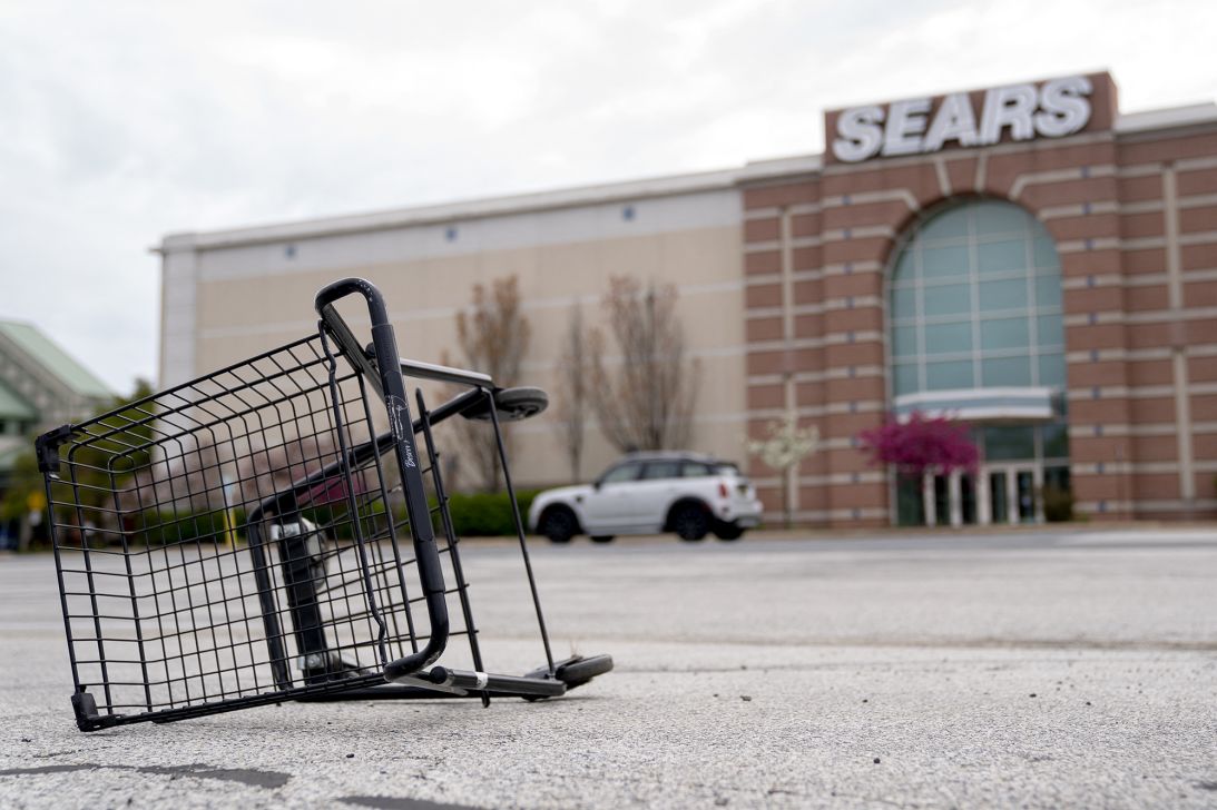 A shopping cart sits tipped over in the parking lot in front of a Sears store at Concord Mall in Wilmington, Delaware, in April 2022.