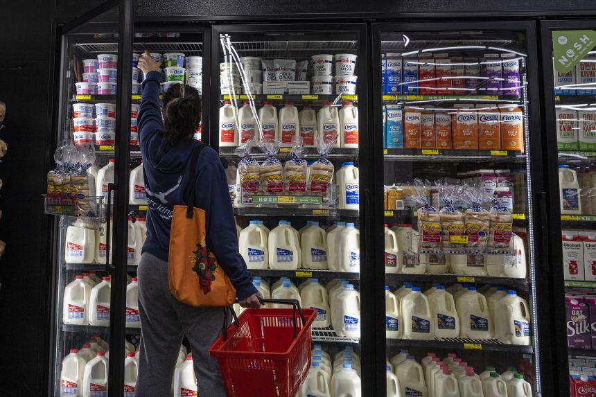 A shopper reaches for cottage cheese inside a grocery store in San Francisco, California, in May 2022.