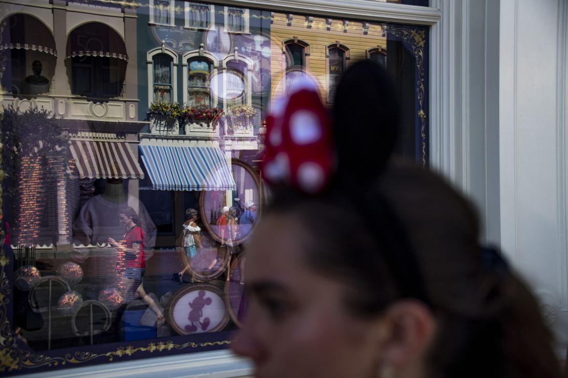 A woman wearing Minnie Mouse ears walks down Main Street USA at the Magic Kingdom Park at Walt Disney World in Orange County, Florida on June 1, 2022.