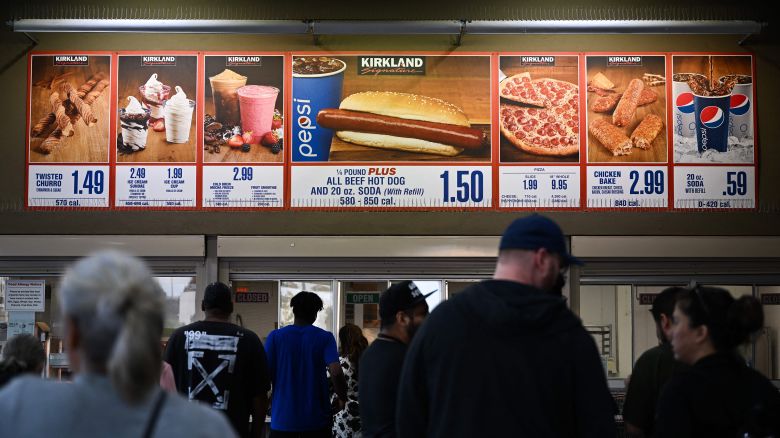 Customers wait in line to order below signage for the Costco Kirkland Signature $1.50 hot dog and soda combo, which has maintained the same price since 1985 despite consumer price increases and inflation, at the food court outside a Costco Wholesale Corp. store on June 14, 2022 in Hawthorne, California.