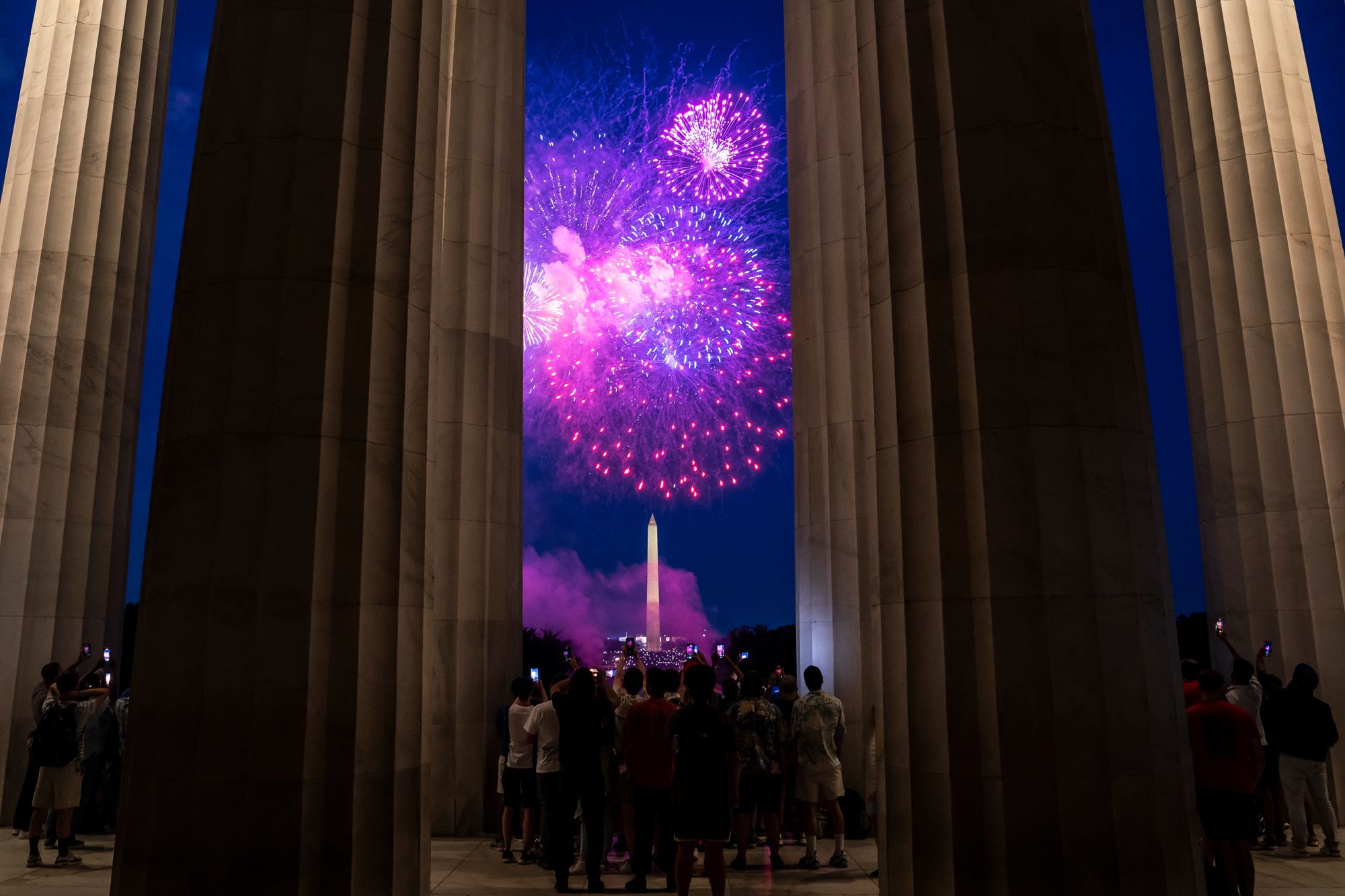 Spectators watch from the Lincoln Memorial as fireworks erupt over the Washington Monument on July 4, 2022.