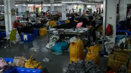La imagen muestra a trabajadores confeccionando ropa en una fábrica de prendas que abastece a Shein, una empresa de comercio electrónico de moda rápida transfronteriza en Guangzhou, China, en julio de 2022.