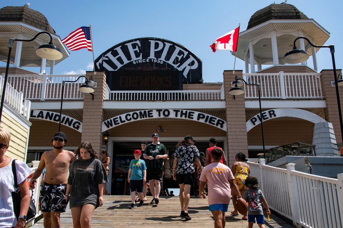 Visitors are seen at the entrance to the pier at Old Orchard Beach in York County, Maine. New England relies heavily on tourism dollars from Canadian visitors.