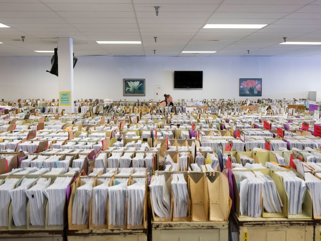 In this June 2022 photo, Margaret Moore, an IRS clerk, searches through taxpayer documents that have been stored in the cafeteria due to a lack of space at the IRS campus in Austin, Texas.