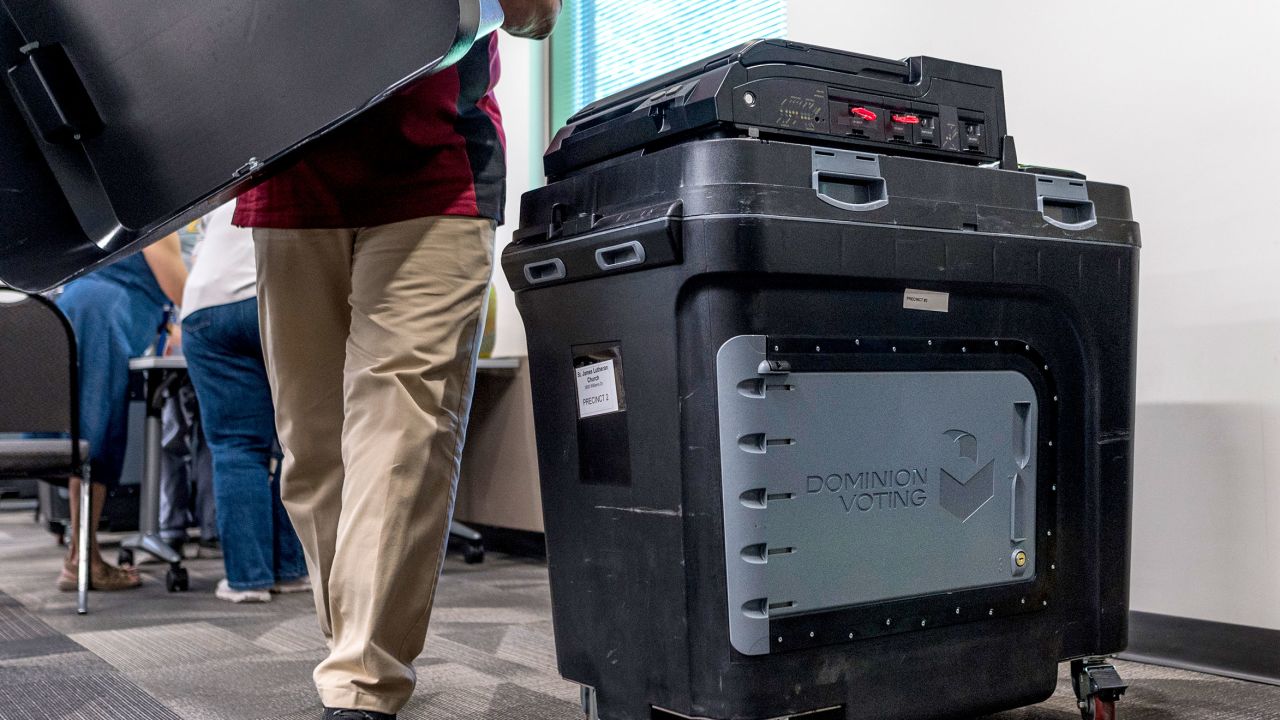 An election judge sets up a Dominion voting machine, during a public accuracy test of voting equipment in Burnsville, Minnesota, on August 3, 2022.