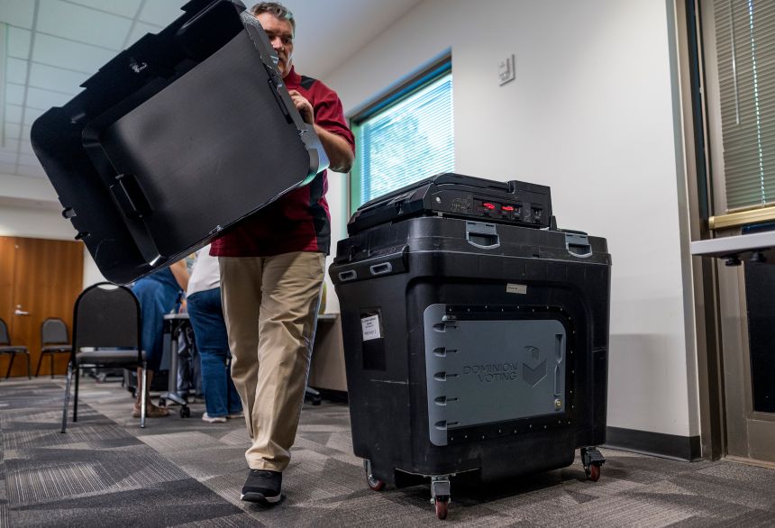 An election judge sets up a Dominion voting machine during a public accuracy test of voting equipment on August 3, 2022 in Burnsville, Minnesota.