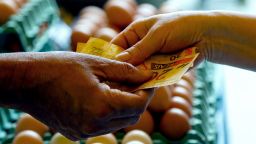 Un cliente paga en efectivo en un puesto de huevos en el mercado callejero de Sao Paulo, Brasil, el 25 de agosto de 2022.
