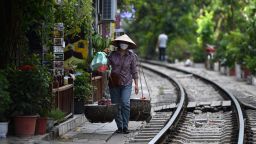 A street vendor walks along a railway line that passes through an old residential area in central Hanoi on August 28, 2022. (Photo by Nhac NGUYEN / AFP) (Photo by NHAC NGUYEN/AFP via Getty Images)