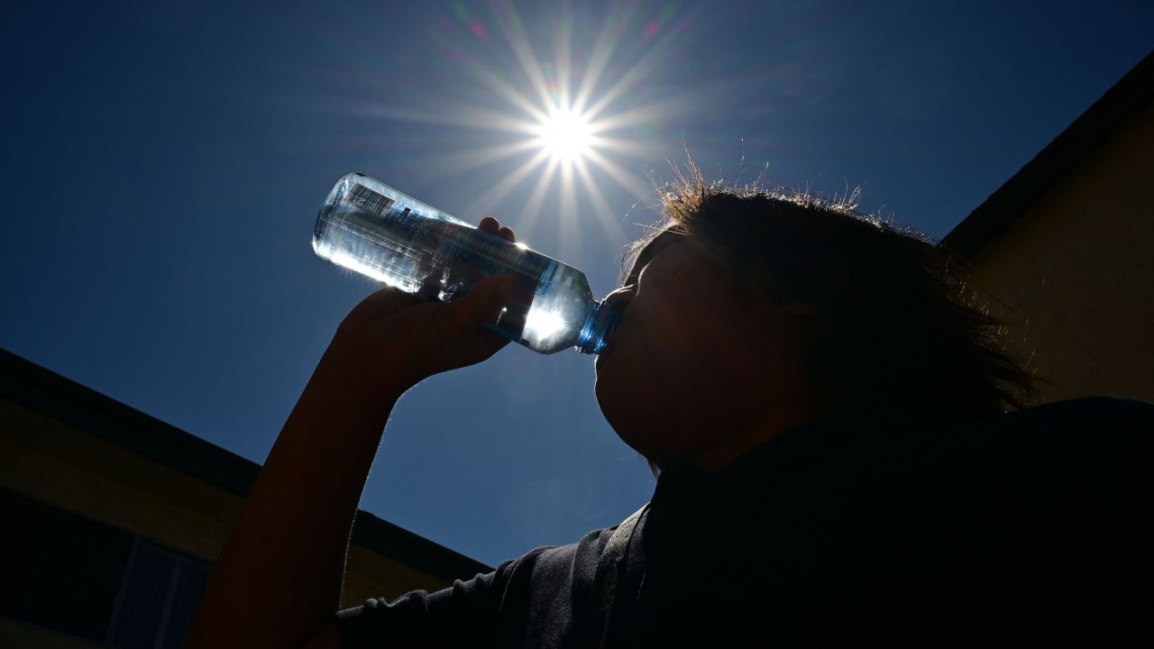 A child sips water from a bottle under a scorching sun on August 30, 2022 in Los Angeles, California. - Forecasters said the mercury could reach as high as 112 Fahrenheit (44 Celsius) in the densely populated Los Angeles suburbs in the next week as a heat dome settles in over parts of California, Nevada and Arizona. (Photo by Frederic J. BROWN / AFP) (Photo by FREDERIC J. BROWN/AFP via Getty Images)