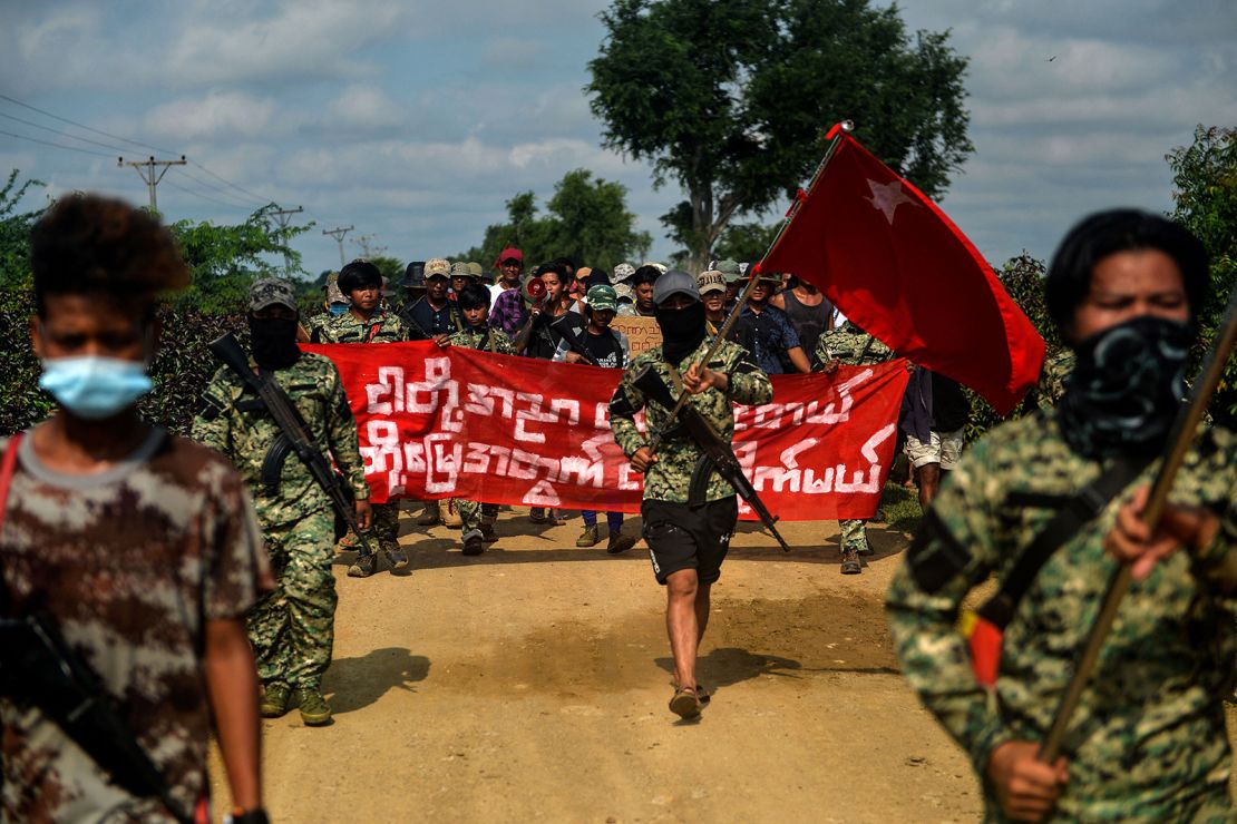 Anti-coup fighters escort protesters as they take part in a demonstration against the military coup in Sagaing, Myanmar on September 7, 2022.