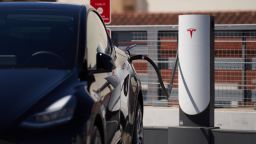 A Tesla vehicle is plugged into a Tesla charging station in a parking lot on September 22, 2022 in Santa Monica, California.