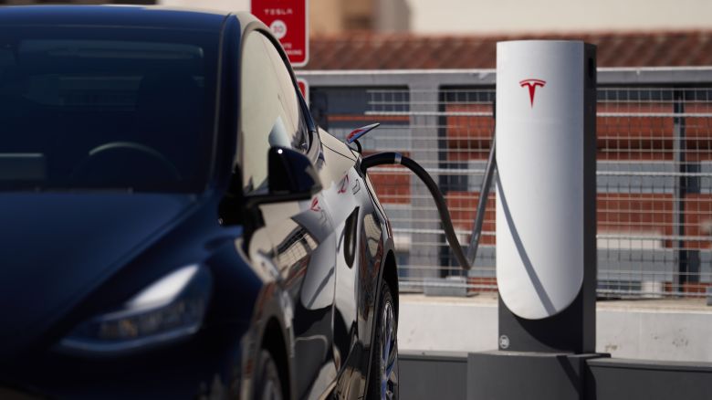 A Tesla vehicle is plugged into a Tesla charging station in a parking lot on September 22, 2022 in Santa Monica, California.