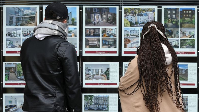 People look at residential properties displayed for sale in the window of an estate agents' in London in September 2022.