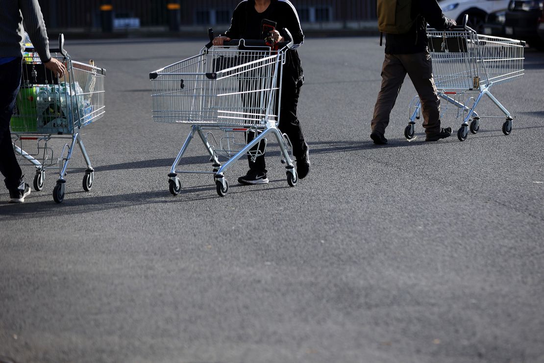 Customers push shopping carts outside a Lidl Stiftung & Co. KG supermarket in Berlin, Germany, on Tuesday, Oct. 4, 2022.