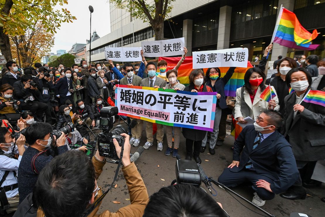 Plaintiffs and supporters react in front of the Tokyo District Court on November 30, 2022, following a ruling in a lawsuit filed by same-sex couples seeking damages from the government.