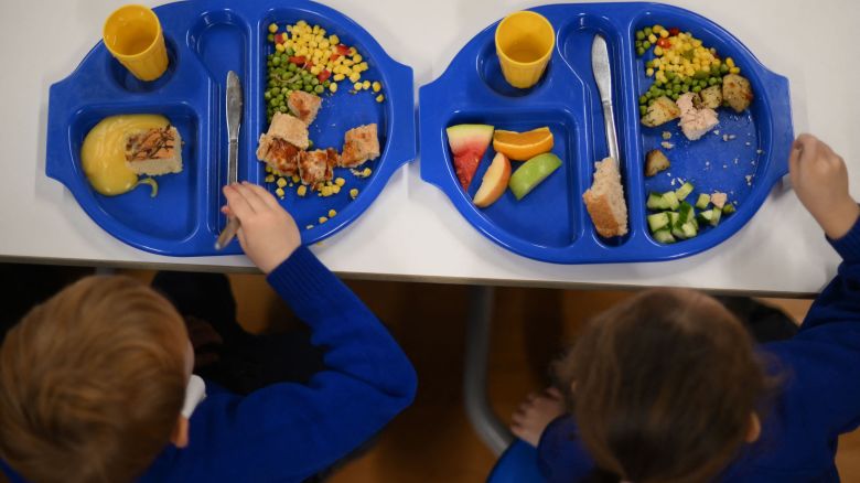 Children eat during lunch-break at St Mary's RC Primary School, in Battersea, south London, on November 29, 2022. - With UK inflation hovering around the highest level in four decades, triggering a cost-of-living crisis, children are increasingly bringing cheaper food from home, in some cases donated. Children in England whose families are deemed by the government to be the poorest are entitled to a free school meal. At 48 percent of pupils, St Mary's has one of the highest proportions in Britain entitled to a taxpayer-funded lunch. (Photo by Daniel LEAL / AFP) (Photo by DANIEL LEAL/AFP via Getty Images)