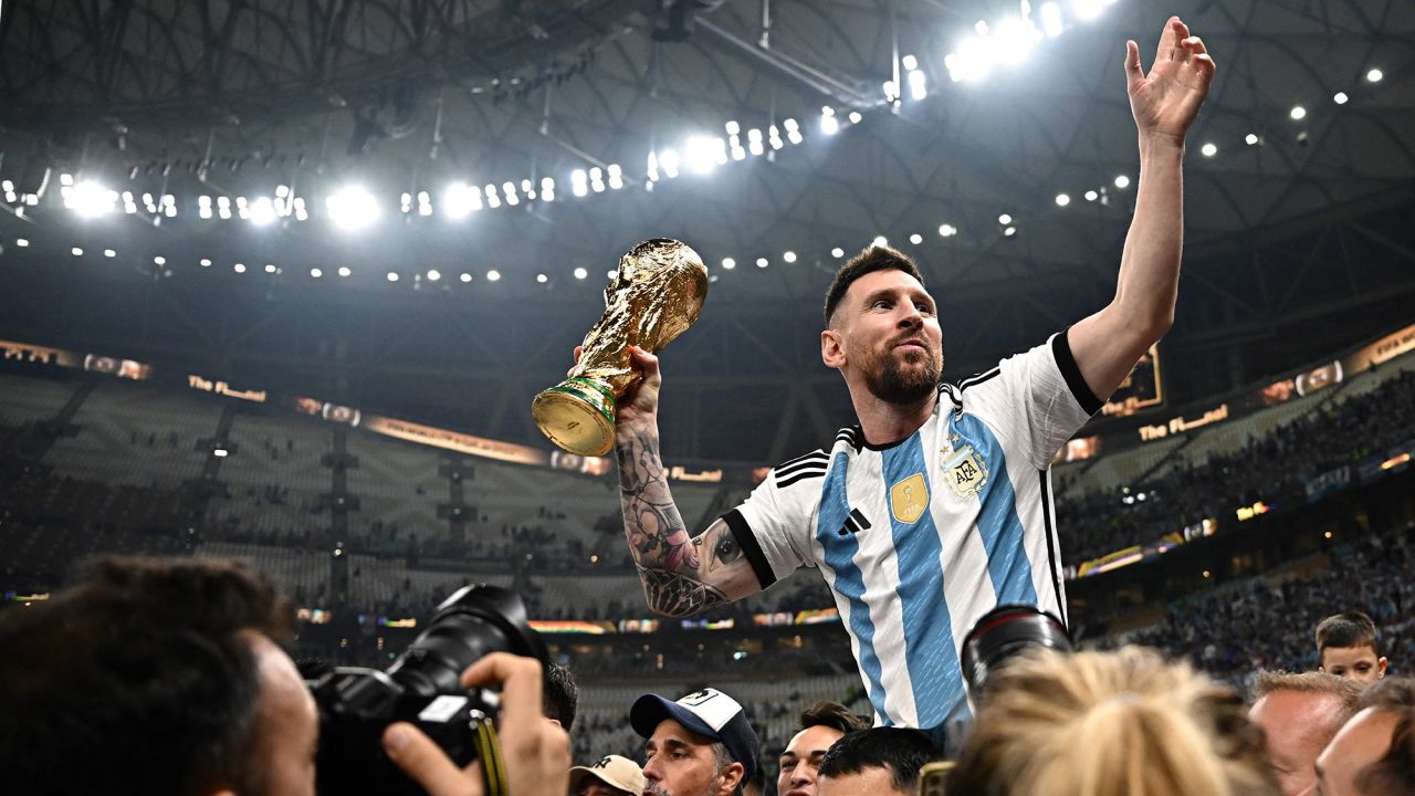 Argentina's captain and forward #10 Lionel Messi (R) holds the FIFA World Cup Trophy following the trophy ceremony after Argentina won the Qatar 2022 World Cup final football match between Argentina and France at Lusail Stadium in Lusail, north of Doha on December 18, 2022.