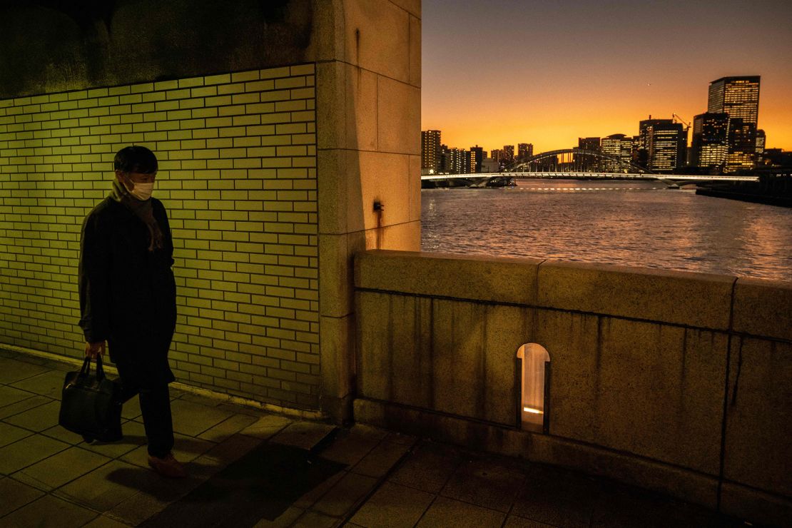 A man walks on a bridge in the faint light of sunset in Tokyo on December 20, 2022. Residents of Japan's capital city will get nine hours and 44 minutes of daylight on winter solstice.