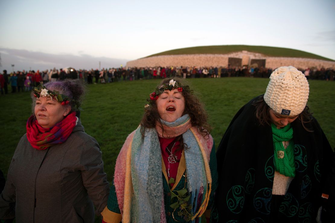 A woman chants as people gather in a circle to witness the winter solstice on December 21, 2022, in Newgrange, Ireland.