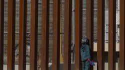 TOPSHOT - Venezuelan migrant George, 5, stands by the bars of the border wall holding a Captain America action figure while staying with his family on the Rio Grande river in Ciudad Juarez, Chihuahua state, Mexico on December 27, 2022. - The US government's two-year-old policy of invoking Covid-19 precautions to turn away hundreds of thousands of migrants at the Mexican border will remain in place for now, the Supreme Court ruled Tuesday. The decision to uphold the controversial rule known as Title 42 stemmed off a looming political crisis for President Joe Biden, as thousands waited at the southern border in expectation the policy was about to end. (Photo by Herika Martinez / AFP) (Photo by HERIKA MARTINEZ/AFP via Getty Images)