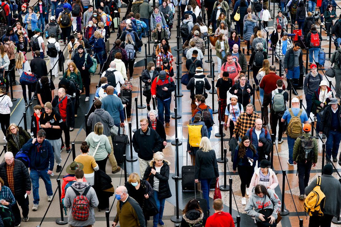 Travelers wait in line to pass through security at Denver International Airport in Colorado on December 28, 2022. The winter holiday travel season can be particularly crowded and stressful.