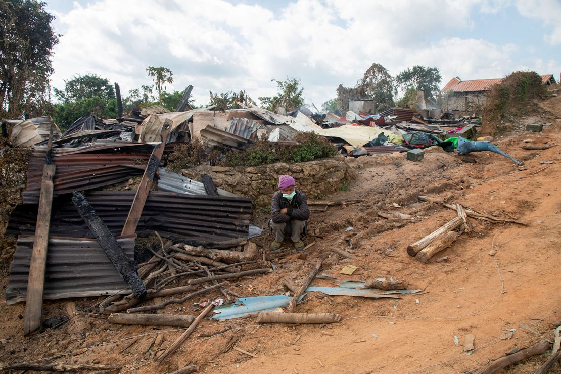 A man sits in front of a house that was destroyed by an air strike in Shan state, Myanmar on December 14, 2022.