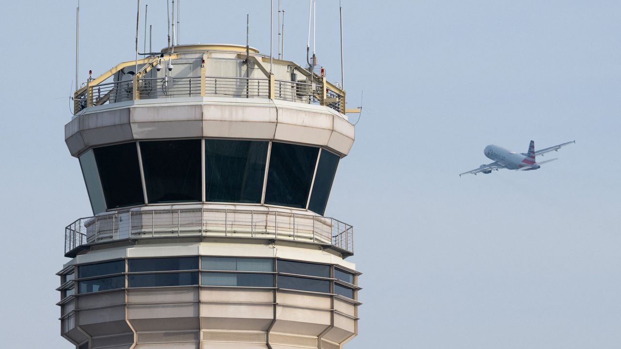 An American Airlines Airbus A319 airplane takes off past the air traffic control tower at Ronald Reagan Washington National Airport in Arlington, Virginia, January 11, 2023. The US Federal Aviation Authority  said Wednesday that normal flight operations "are resuming gradually" across the country following an overnight systems outage that grounded departures. (Photo by SAUL LOEB / AFP) (Photo by SAUL LOEB/AFP via Getty Images)