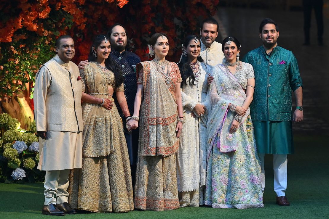 Mukesh Ambani (L) and his wife Nita (4L) pose with their younger son Anant (3L), his fiancée Radhika Merchant (2L) and other family members during Anant's engagement ceremony in Mumbai on January 19, 2023.