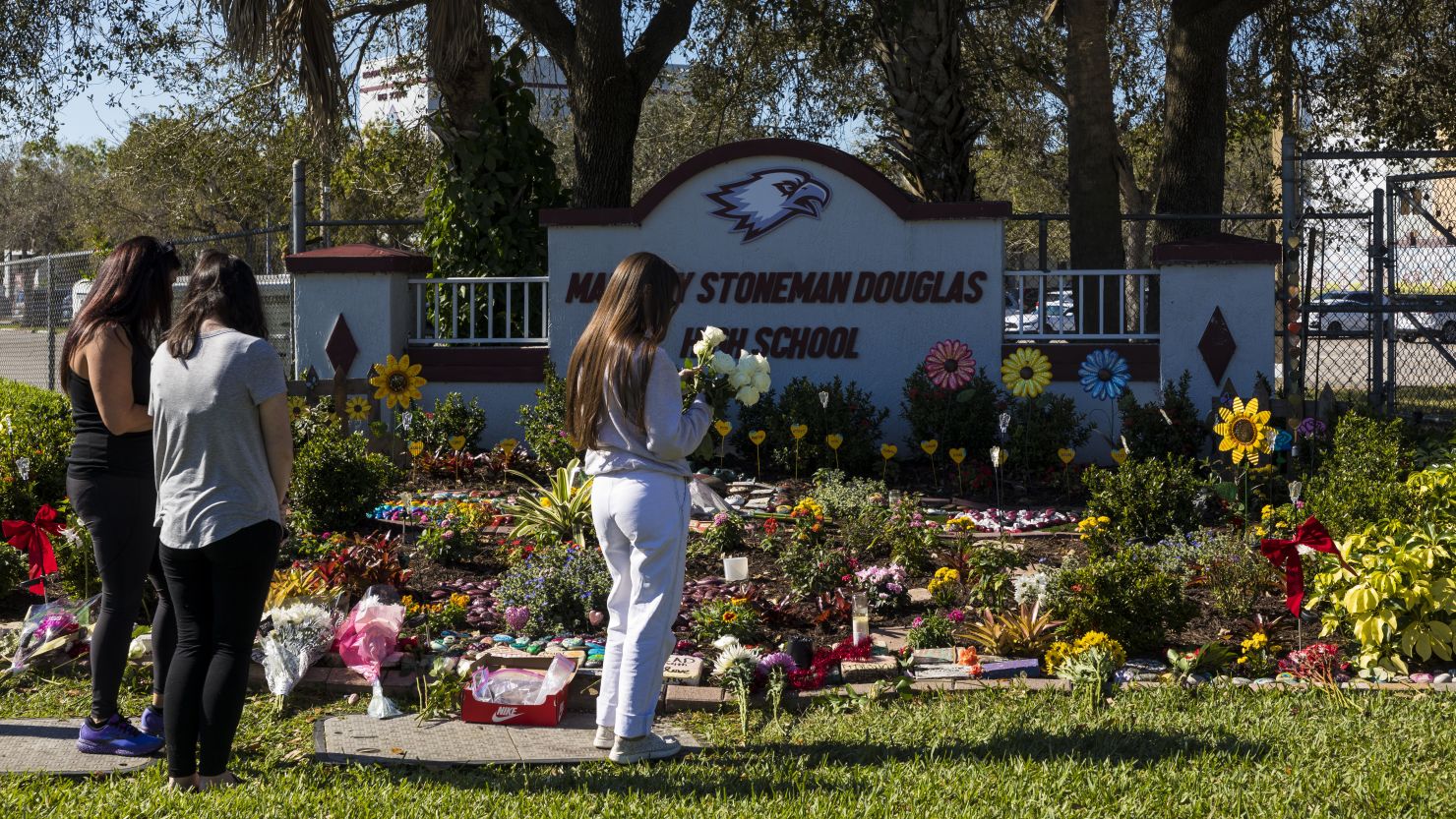 People visit a memorial at Marjory Stoneman Douglas High School to honor those killed on the 5th anniversary of the mass shooting on February 14, 2023 in Parkland, Florida. On February 14, 2018 fourteen students and three staff members were killed during the shooting at the school.