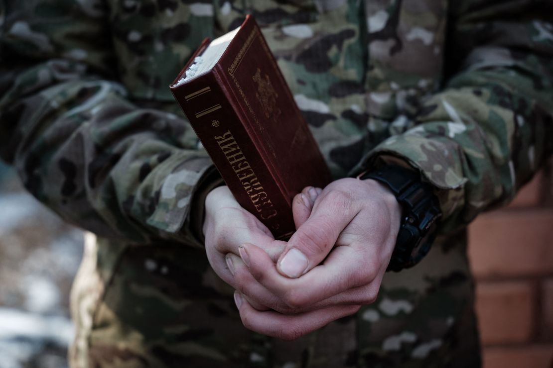 A Ukrainian serviceman of the 95th Air Assault Brigade holds the Bible during a prayer before their departure to the frontline in the Donetsk region on February 22, 2023.