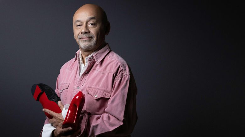 French shoe designer Christian Louboutin poses with two of his creations during a photo session in Paris, on March 2, 2023. (Photo by JOEL SAGET / AFP) (Photo by JOEL SAGET/AFP via Getty Images)