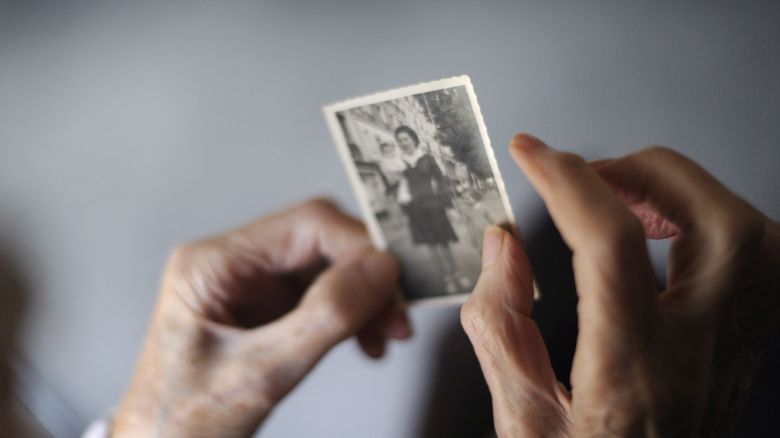 A woman, suffering from Alzheimer's desease, looks at an old picture of herself on March 18, 2011 in a retirement house in Angervilliers, eastern .   AFP PHOTO / SEBASTIEN BOZON (Photo by SEBASTIEN BOZON / AFP) (Photo by SEBASTIEN BOZON/AFP via Getty Images)