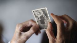 A woman, suffering from Alzheimer's desease, looks at an old picture of herself on March 18, 2011 in a retirement house in Angervilliers, eastern .   AFP PHOTO / SEBASTIEN BOZON (Photo by SEBASTIEN BOZON / AFP) (Photo by SEBASTIEN BOZON/AFP via Getty Images)