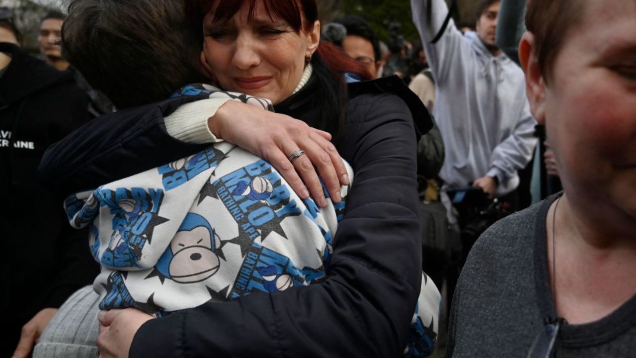 Inessa hugs her son Vitaly after the bus delivering him and more than a dozen other children back from Russian-held territory arrived in Kyiv on March 22, 2023. - More than 16,000 Ukrainian children have been deported to Russia since the February 24, 2022 invasion, according to Kyiv, with many allegedly placed in institutions and foster homes. (Photo by SERGEI CHUZAVKOV / AFP) (Photo by SERGEI CHUZAVKOV/AFP via Getty Images)