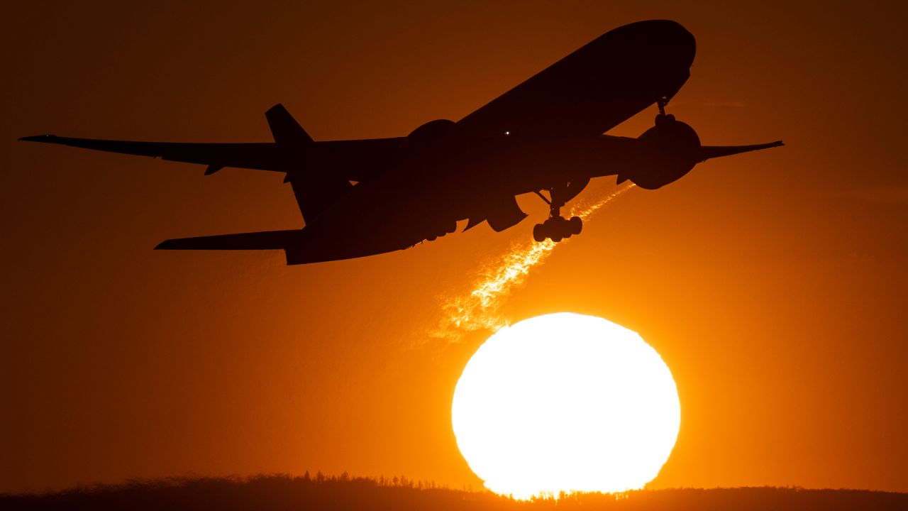 03 April 2023, Hesse, Frankfurt/Main: A passenger plane takes off from Frankfurt Airport in front of the setting sun.