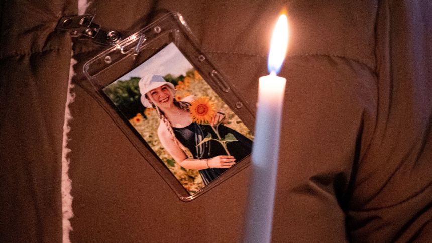 A photo of teacher Abby Zwerner is pinned to a coat during a vigil held for her after she was shot.