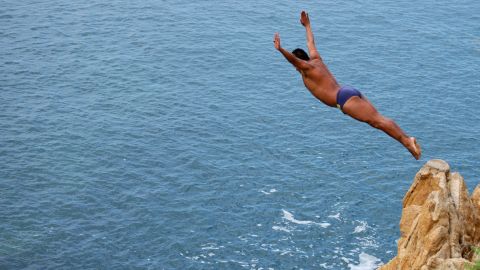 A cliff diver jumps from "La Quebrada" cliff in Acapulco, Mexico, on September 30th, 2007. The tradition of "La Quebrada" goes back to 1934, when two neighbours of Acapulco challenged themselves to demonstrate their courage and decided to measure their forces by throwing themselves to the sea from the stop of a cliff. The rivalry between those two men ended first in a reckless spectacle, and later in a form of earning a living. The myth of "La Quebrada" was born, and today it is almost a religion for its followers. AFP PHOTO/Cecilia del OLMO (Photo by CECILIA DEL OLMO / AFP) (Photo by CECILIA DEL OLMO/AFP via Getty Images)