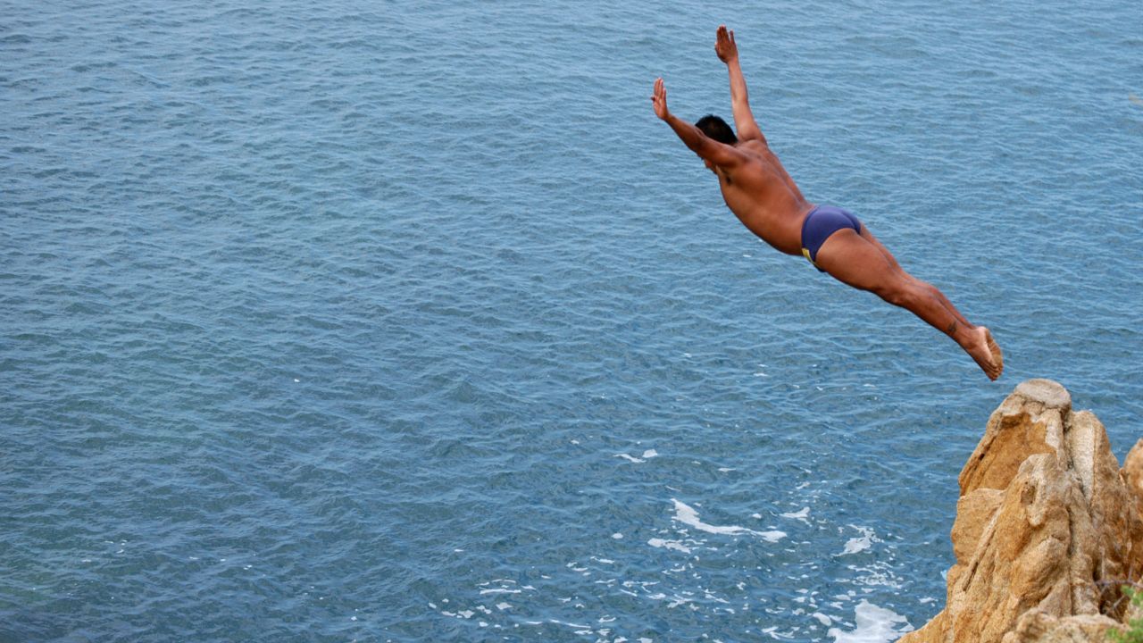 A cliff diver jumps from "La Quebrada" cliff in Acapulco, Mexico, on September 30th, 2007. The tradition of "La Quebrada" goes back to 1934, when two neighbours of Acapulco challenged themselves to demonstrate their courage and decided to measure their forces by throwing themselves to the sea from the stop of a cliff. The rivalry between those two men ended first in a reckless spectacle, and later in a form of earning a living. The myth of  "La Quebrada" was born, and today it is almost a religion for its followers.  AFP PHOTO/Cecilia del OLMO (Photo by CECILIA DEL OLMO / AFP) (Photo by CECILIA DEL OLMO/AFP via Getty Images)