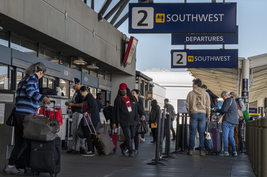 Travelers wait to check in at the Southwest Airlines counter at Oakland International Airport in Oakland, California, on April 18, 2023, after