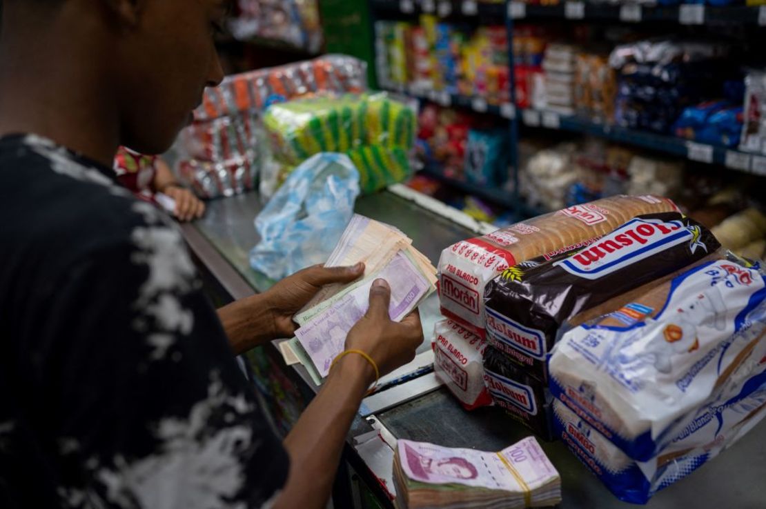 Un hombre cuenta billetes de bolívares para comprar alimentos en un supermercado de Caracas, el 28 de abril de 2023.