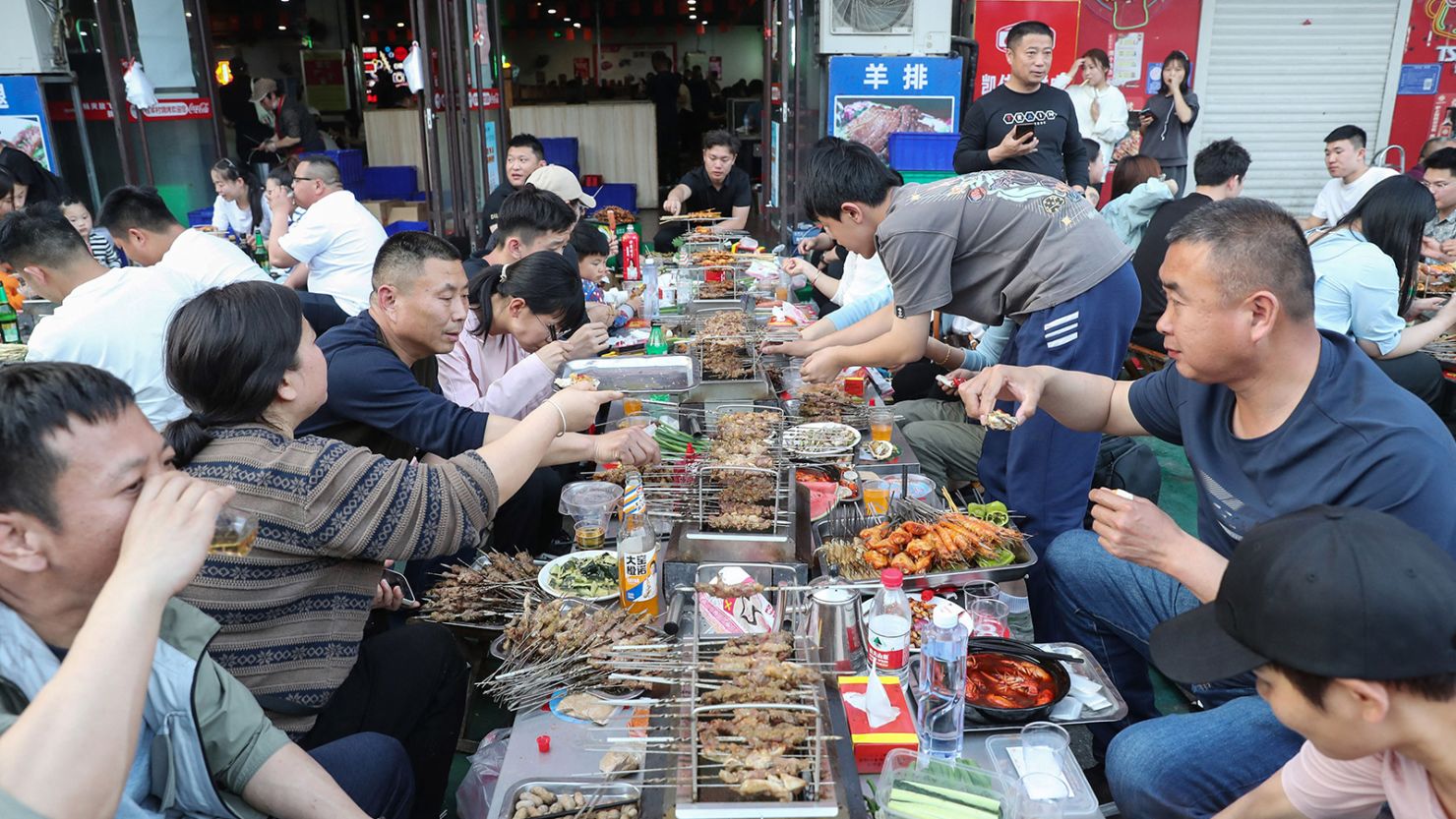 People eat barbecue skewers in Zibo during the 5-day Labor Day holiday on May 2, 2023.