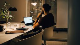 Side view of dedicated male professional working late at illuminated desk in coworking space